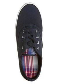 Baskets en toile noire avec lacets noirs et semelle blanche, avec un motif à carreaux rouge, blanc et bleu sur la semelle intérieure.