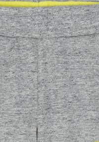 Grijze sweatpants van een gestructureerde stof, met een gele elastische tailleband en minimale stiksels. Eenvoudig en functioneel ontwerp.