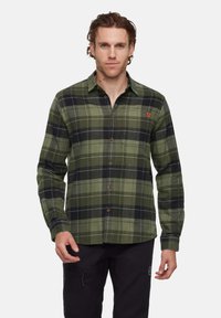 Groen en zwart geruite knoopoverhemd met een kraag, lange mouwen en een borstzak. Voorzien van bruine knopen en een logo op de borst.