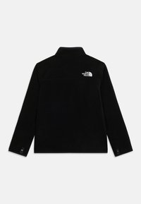 Μαύρο φλις μπουφάν με μακριά μανίκια, ψηλό γιακά, μανσέτες με κουμπιά snap και λευκό λογότυπο The North Face στην πάνω δεξιά πλευρά της πλάτης.