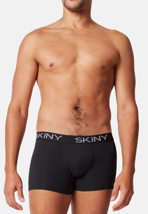 Schwarze Boxershorts aus dehnbarem Stoff mit einem weichen Bund. Mit Logo entlang des Bundes und einem figurbetonten Design.