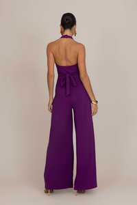 Jumpsuit viola senza maniche con un dettaglio di legatura sul retro e silhouette a gamba larga, realizzato in tessuto morbido, che mette in mostra un design senza schiena.