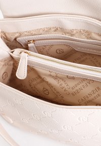 Borsa a mano beige chiaro con texture, caratterizzata da un motivo in rilievo, con una tasca interna con zip e una fodera stampata con logo in marrone chiaro.