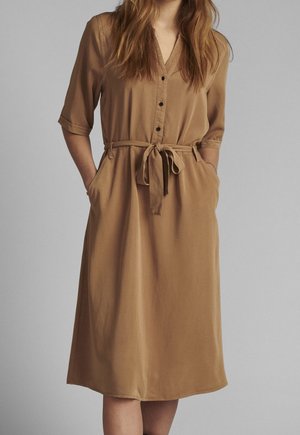 Brown button-up dress with short sleeves, a V-neck, waist tie, and side pockets, made of a smooth, lightweight fabric.
