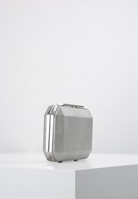 Silver textured rectangular clutch purse with metallic edges and top clasp placed on a white surface against a plain background.