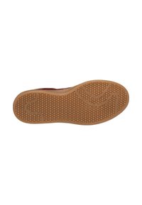 Semelle de chaussure avec un motif alvéolaire texturé, en caoutchouc brun doux, de forme arrondie, présentant un motif de vague subtil le long du bord.