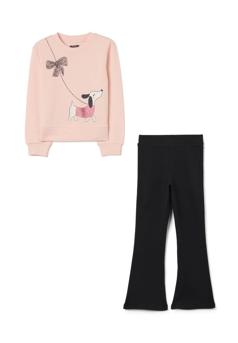 Sweatshirt rose clair avec un graphisme de chien et un détail en nœud, associé à des leggings évasés noirs, tous deux en tissu doux et extensible.