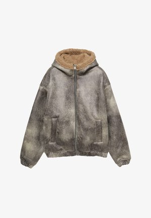 Grå struktureret jakke med en sandfarvet pelsforet hætte, frontlynlås, to sidelommer og ribbede manchetter for en sikker pasform.