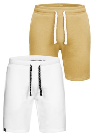 Deux paires de shorts décontractés, un beige avec cordon blanc, un blanc avec cordon noir, tous deux en tissu doux.