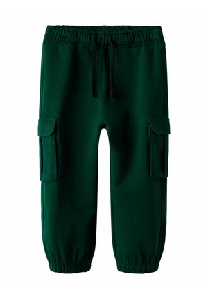 Pantalons de survêtement verts en tissu doux, dotés d'une taille élastique, d'un cordon de serrage et de deux poches cargo sur les côtés. Poignets froncés aux chevilles.