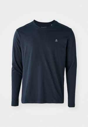 Ilgi piedurkņu tumši zila t-krekls, izgatavots no mīksta kokvilnas, ar apaļu kakla izgriezumu un mazu baltu logo kreisajā krūtīs.