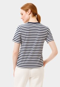 Námořnické a bílé pruhované tričko s krátkým rukávem, kulatým výstřihem a hladkým pleteným povrchem, s rovnými liniemi a mírně delší zadní částí.