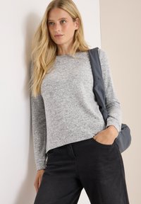 Grå sweater med långa ärmar, rund halsringning och strukturerad tyg, tillsammans med svarta byxor och en strukturerad grå axelväska.