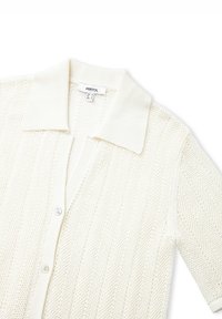 Crème gebreide cardigan met een gestructureerd ruitpatroon, korte mouwen, een platte kraag en een sluiting met knopen aan de voorkant. Licht en ademend materiaal.