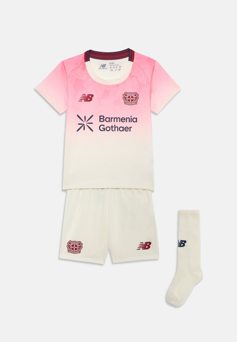 Lasten jalkapallovarusteet, jotka koostuvat vaaleanpunaisesta ja valkoisesta liivistä, valkoisista shortseista ja yhteensopivista valkoisista sukista, joissa on punaisia logoja ja yksityiskohtia.