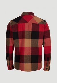 Punainen ja musta ruudullinen flanellipaita suurilla neliöillä, pitkät hihat ja napitettu hihansuu. Pehmeä rakenne, jossa on kaulus ja selkäosa.