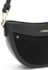 Borsa a tracolla nera con forma curva, che combina texture in pelle liscia e suede morbido, caratterizzata da accessori in oro e dettagli cuciti.