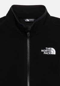 Μαύρο φλις μπουφάν με ολόκληρο φερμουάρ και αυξημένο γιακά, με λευκό κεντημένο λογότυπο The North Face στο στήθος.