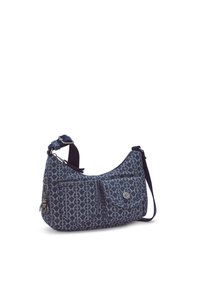 Blue patterned fabric shoulder bag with a curved shape, two front pockets, and an adjustable strap. Features silver hardware accents.