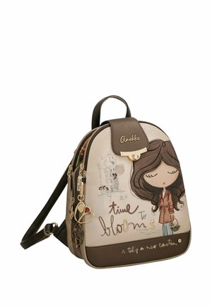 Mochila compacta marrón y beige con chica ilustrada, encantos decorativos y texto "time to bloom" y "a tulip a new emotion."