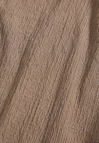 Textured fabric in a brown hue, featuring a wrinkled surface with fine, raised lines creating a structured appearance.