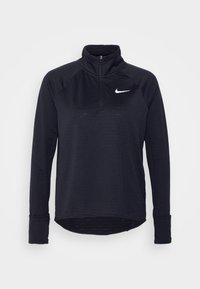 Musta, pitkähihainen Nike-pullover, jossa on vetoketju kauluksessa. Materiaalissa on teksturoitu pinta ja vasemmassa rinnassa valkoinen logo. Pyöristetty helma.