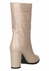Stivaletto in pelle beige con una texture liscia, punta rotonda e tacco a blocco di media altezza. Presenta un design senza cuciture e una leggera piegatura.