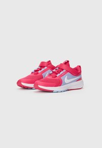 Chaussures de sport pour enfants en rouge et bleu clair avec le swoosh blanc de Nike, dotées de bandes Velcro et de dessus en tissu en maille.