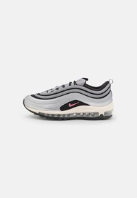 Nike Air Max 97-sneakers har en silver och svart vågig design, mesh-accenter, rosa logotyp och synlig luftkuddsdämpning i sulan.