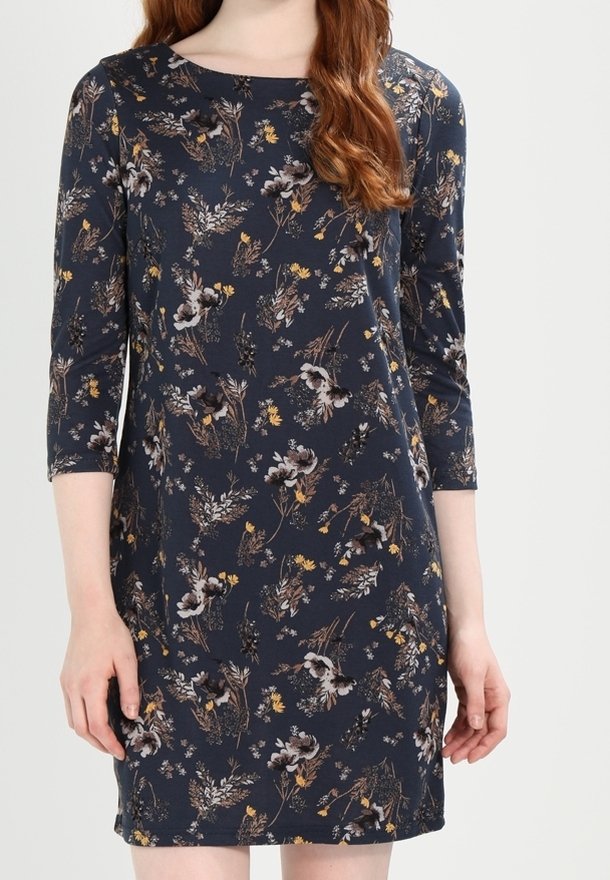 Marinblå klänning med trekvartslånga ärmar, prydd med ett blommönster i nyanser av vitt, gult och brunt. Mjuk, slät spets med rak skärning.