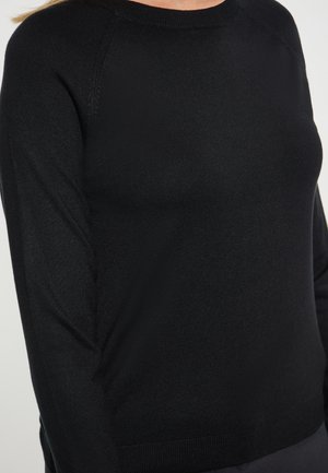 Maglione nero a maglia con scollo a girocollo, texture liscia e polsini e orlo a coste. Progettato con maniche raglan per una maggiore libertà di movimento.