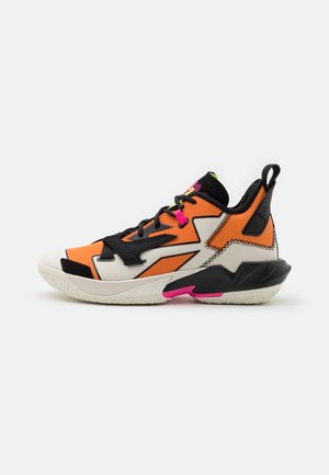 Chaussure de sport montante orange, noire, blanche et rose avec des lacets noirs, des motifs géométriques et une semelle blanche texturée.