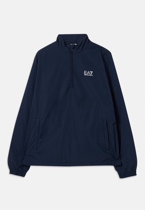 Tumši zili garo piedurkņu pulovers ar pusi rāvējslēdzēja, elastīgām aprocēm, divām sānu kabatām un baltu EA7 Emporio Armani logotipu uz krūtīm.