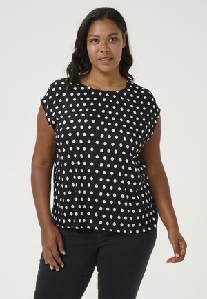 Top negro con lunares blancos, de manga corta, cuello redondo, fabricado en un tejido ligero, que presenta un ajuste holgado y una textura suave.