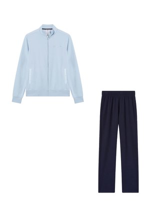 Giacca azzurra con zip e tasche abbinata a pantaloni blu scuro a vita elastica, entrambi distesi su sfondo bianco.