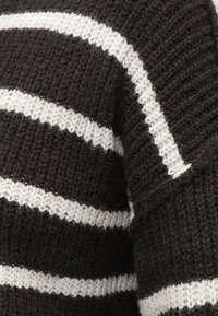 Μπλε και λευκό ριγωτό πλεκτό πουλόβερ, με υφή από ύφασμα που έχει φαρδιές ρίγες και χαλαρή εφαρμογή.