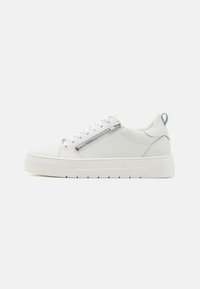 White leather sneaker with a textured rubber sole, featuring a side zipper accent and laces. Rounded toe and rear pull tab for easy wear.