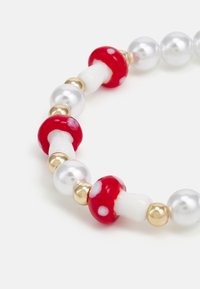 Pulseira de contas com contas em forma de cogumelos vermelhos e brancos brilhantes, intercaladas com contas esféricas douradas e brancas brilhantes.