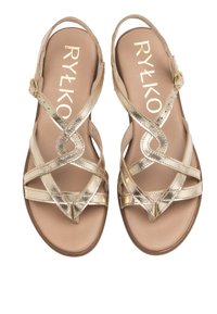 Gouden metallic sandalen met kruisende bandjes, enkelgesp en een gladde, platte zool. Merkennaam "RYŁKO" afgedrukt op de binnenzool.