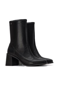 Bottines en cuir noir avec un bout carré, un talon empilé et un design minimaliste. Présente des coutures subtiles et un accent en matériel décoratif.