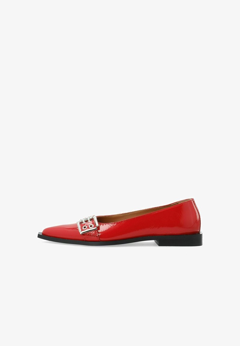 Chaussures plates en cuir verni rouge avec un bout pointu, ornées d'une boucle en argent décorative et d'un petit talon noir. Texture lisse et brillante.