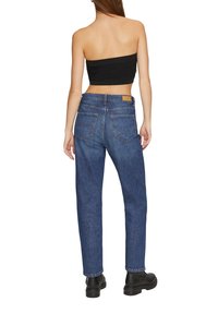 Hoge taille blauwe denim jeans met vijf zakken, rechte pijpen, minimale stikseldetails en een bruine leren logo patch op de taille.