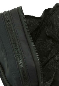 Bolsita de tela negra con doble cremallera, que presenta un exterior liso y un forro interior con un diseño monocromático.