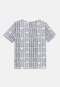Camiseta blanca de manga corta con un patrón negro de logotipos de Puma en toda la prenda, dispuestos en una cuadrícula, vista desde la parte de atrás.