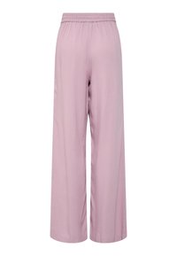 Pantalons larges rose clair en tissu doux. Dotés d'une taille élastique et d'une texture lisse avec une coupe ample.