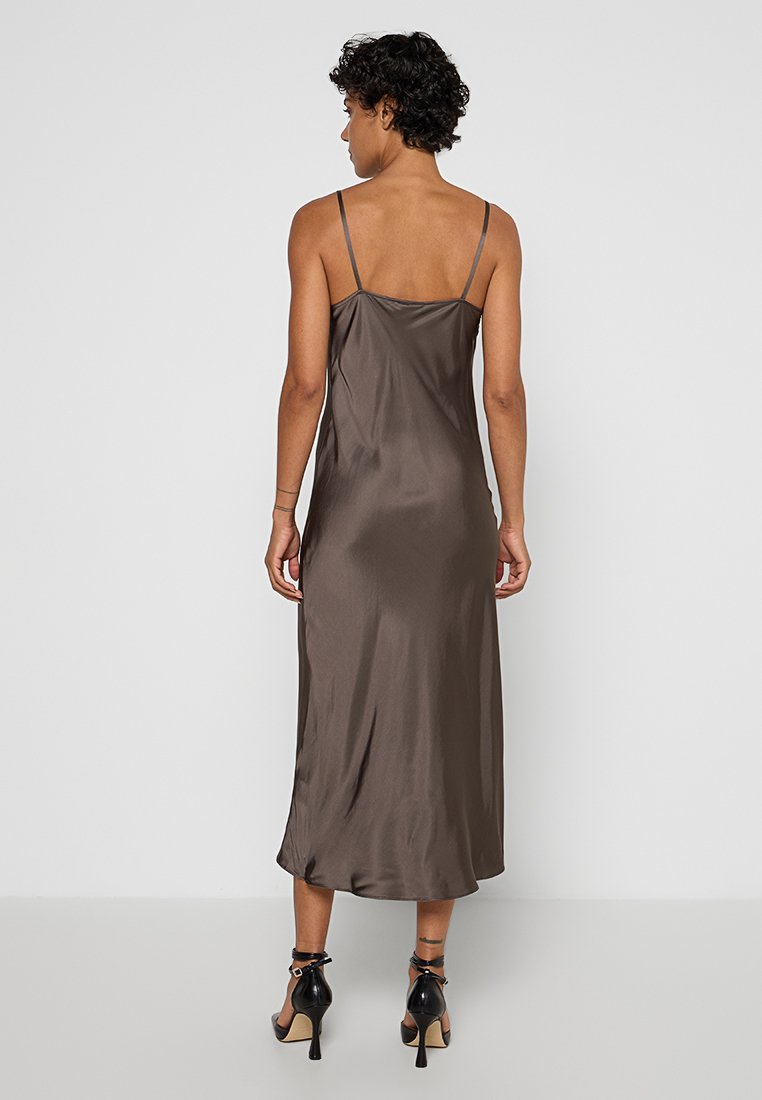 Vestido de satén marrón con tirantes finos, de longitud a media pantorrilla y un diseño fluido. Presenta una textura suave y una silueta simple y elegante.