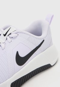 Fialová síťovaná sportovní bota s černým logem Nike, bílou šňůrkovou panelou a texturovanou podrážkou s černou gumovou přilnavostí.