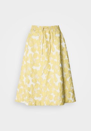 Yellow floral skirt with a textured surface, featuring a gathered waistband and a knee-length A-line shape. Patterns of large yellow flowers on a white background.