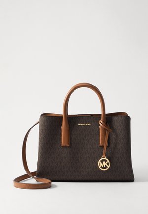 Ciemnobrądzka torebka Michael Kors z jasnobrązowymi uchwytami, długim paskiem na ramię oraz złotym brelokiem z logo MK na jednolitym tle.
