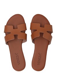 Brune sandaler med et dobbelt rem-design og udskårne detaljer. Fremstillet af glat syntetisk materiale med en flad sål og logo-detalje.